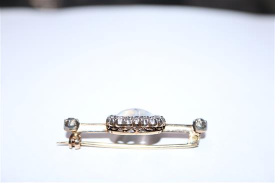 A diamond and moonstone bar brooch, heart-shaped setting in yellow metal (one stone missing), boxed 40mm.